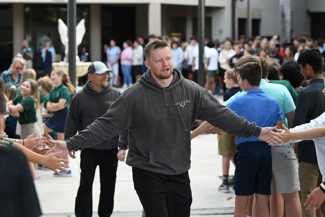 A coach greeting students