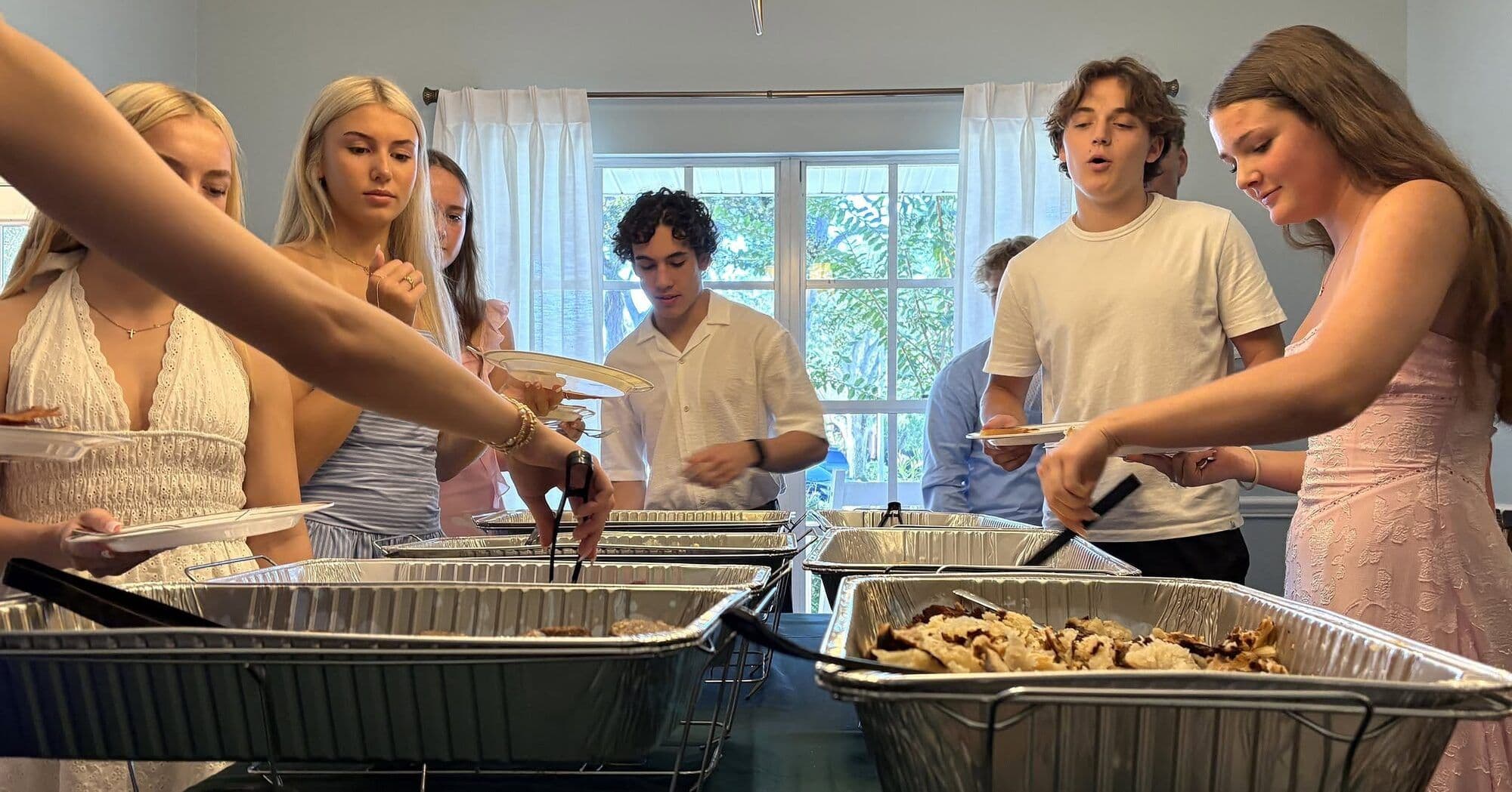 Seniors in formal attire serve themselves from breakfast buffet trays at the annual Senior Breakfast.